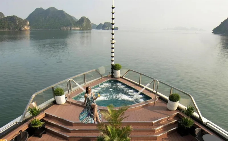 Một phụ nữ thư giãn trong bồn sục ở mũi tàu du lịch giữa các đảo đá vôi vịnh Hạ Long.